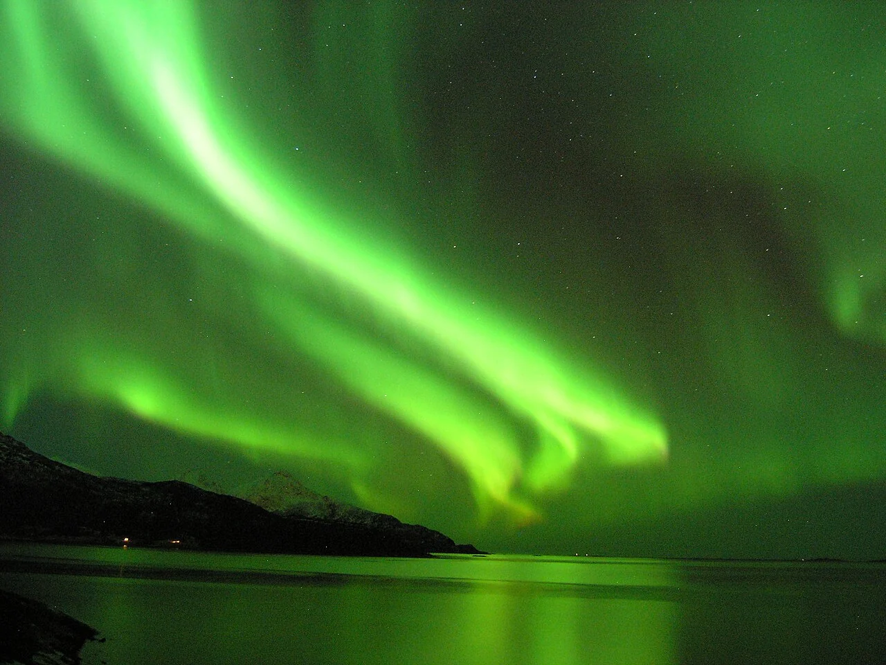 Green aurora reflected in coastal water near Tromsø